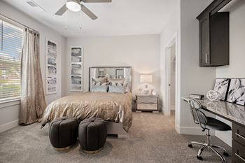 A bedroom with a bed and a desk with a chair